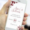 Lembrete de casamento marsala mostrado na tela de um celular, com fundo claro, detalhes florais em tons de vinho e rosa nos cantos e tipografia elegante destacando nomes dos noivos e data do evento.