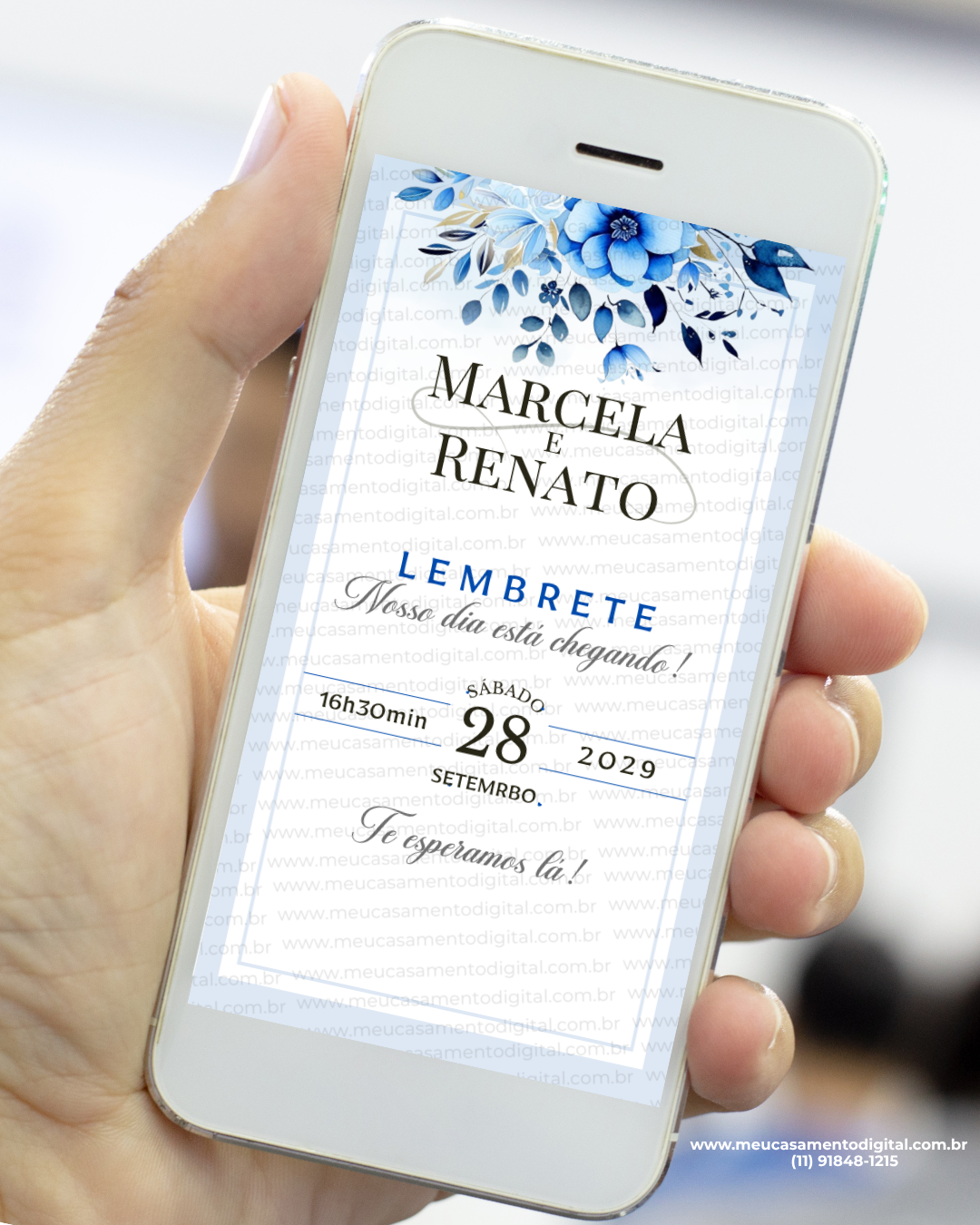 Convite lembrete de casamento azul exibido na tela de um celular, com flores em tons de azul no topo, moldura fina e tipografia elegante com nomes dos noivos, data e horário do evento.