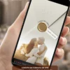 Convite de casamento branco e dourado com fotos exibido em smartphone, com envelope digital, selo dourado e foto do casal.