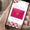 Convite de casamento rosa fúcsia digital exibido em celular, com envelope rosa vibrante, flores em tons de rosa e branco e selo dourado.